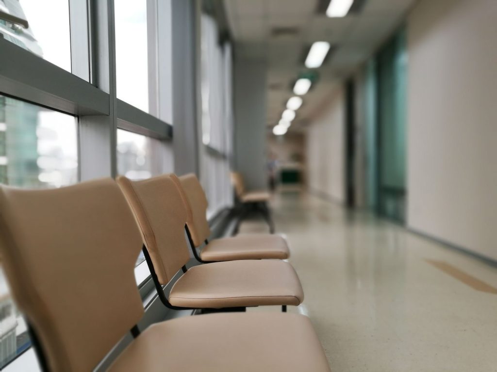 Lege stoelen langs een lichte gang in een zorggebouw
