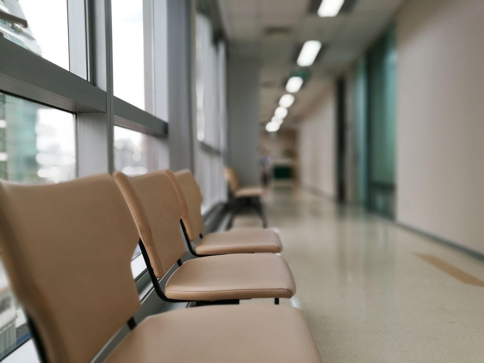 Lege stoelen langs een lichte gang in een zorggebouw